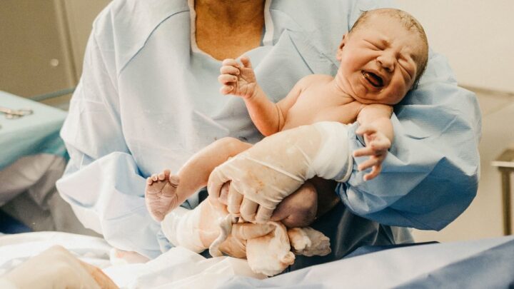 newborn infant being held by a healthcare provider