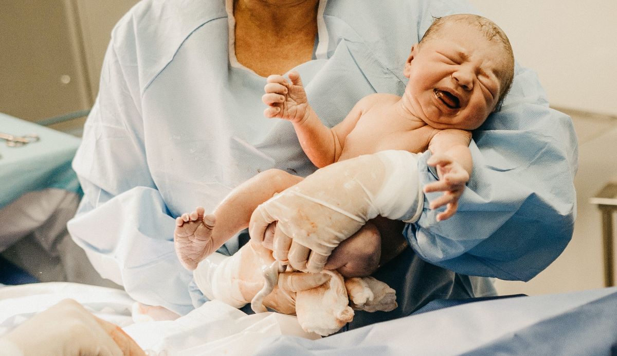 newborn infant being held by a healthcare provider