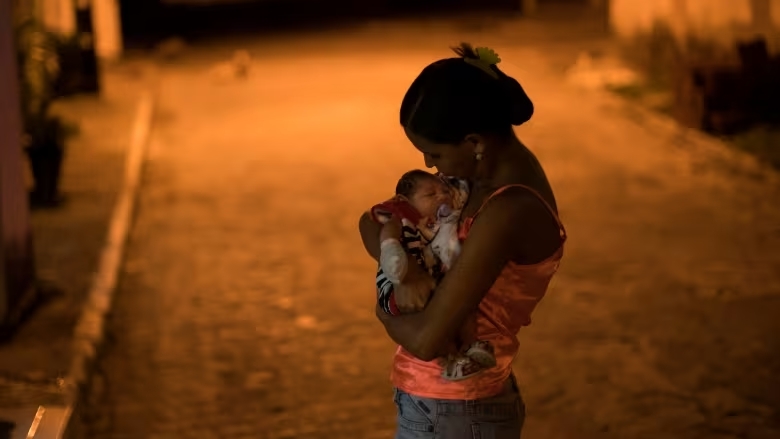 A woman in Brazil holds her son, who was born with severe birth defects